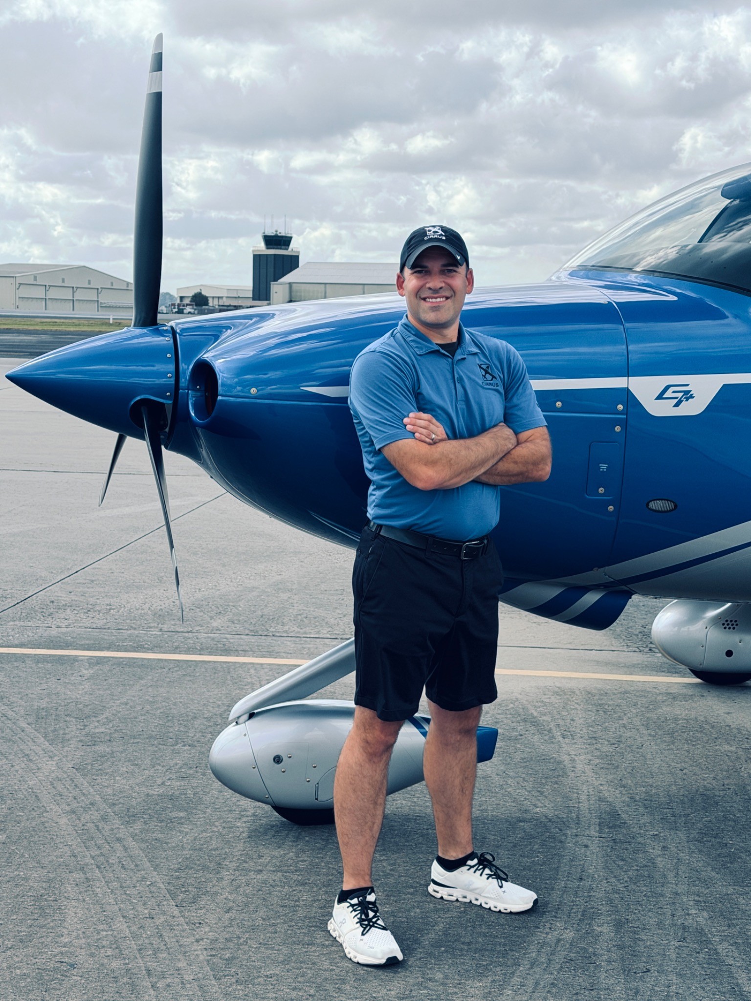 Cole Ruckstuhl standing beside a blue Cirrus SR-series aircraft